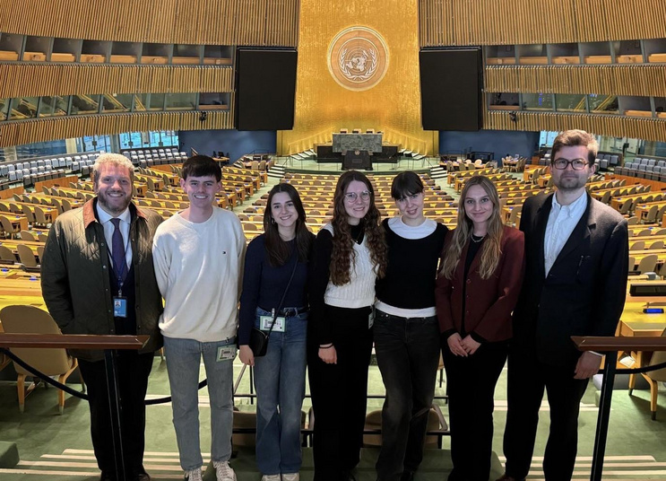 The 2025 Vienna Jessup team and their UN host in the General Assembly Hall at the United Nations in New York.